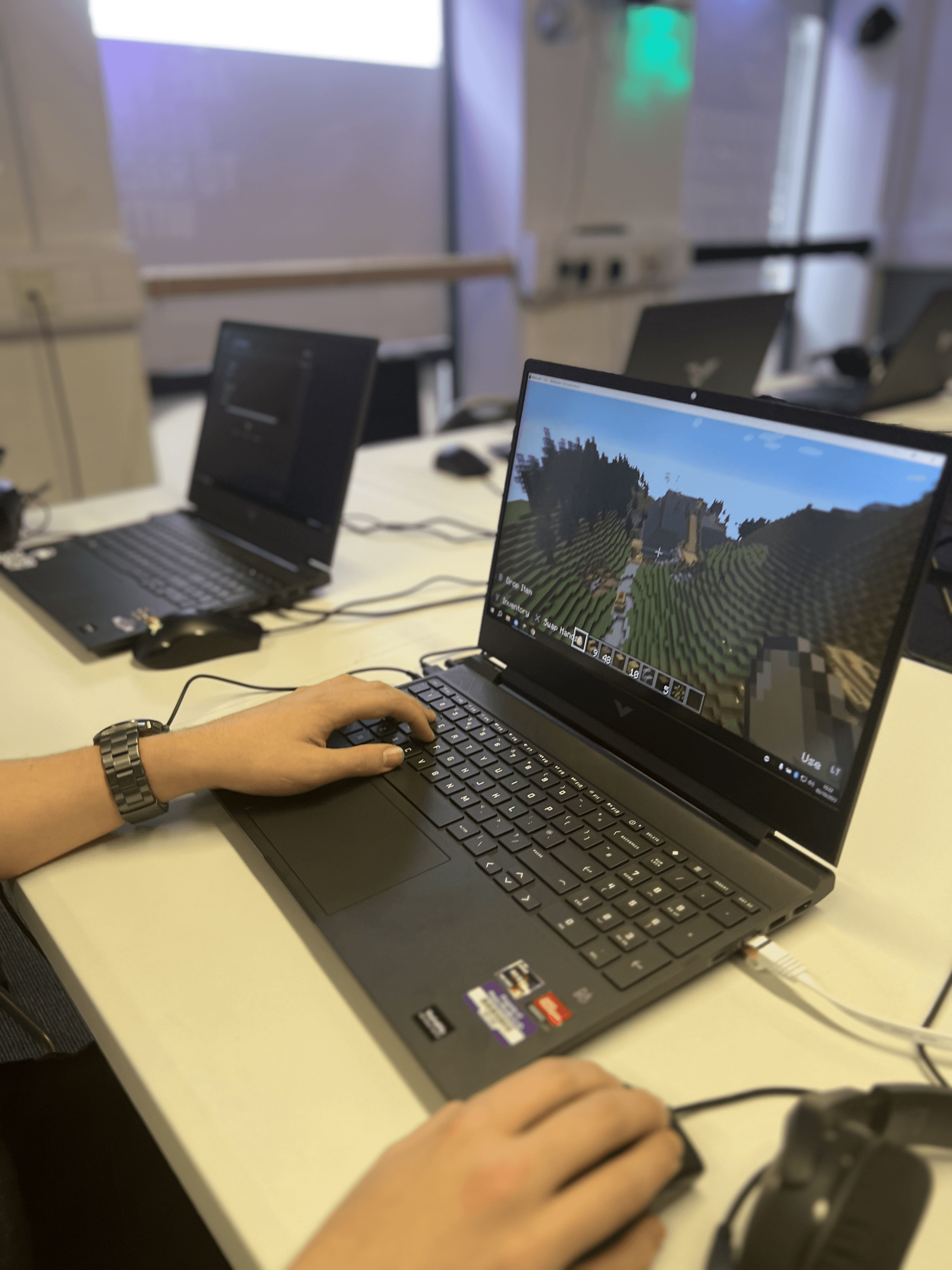 Close-up of a child's hand on a mouse while playing Minecraft during a Player Ready coding club session