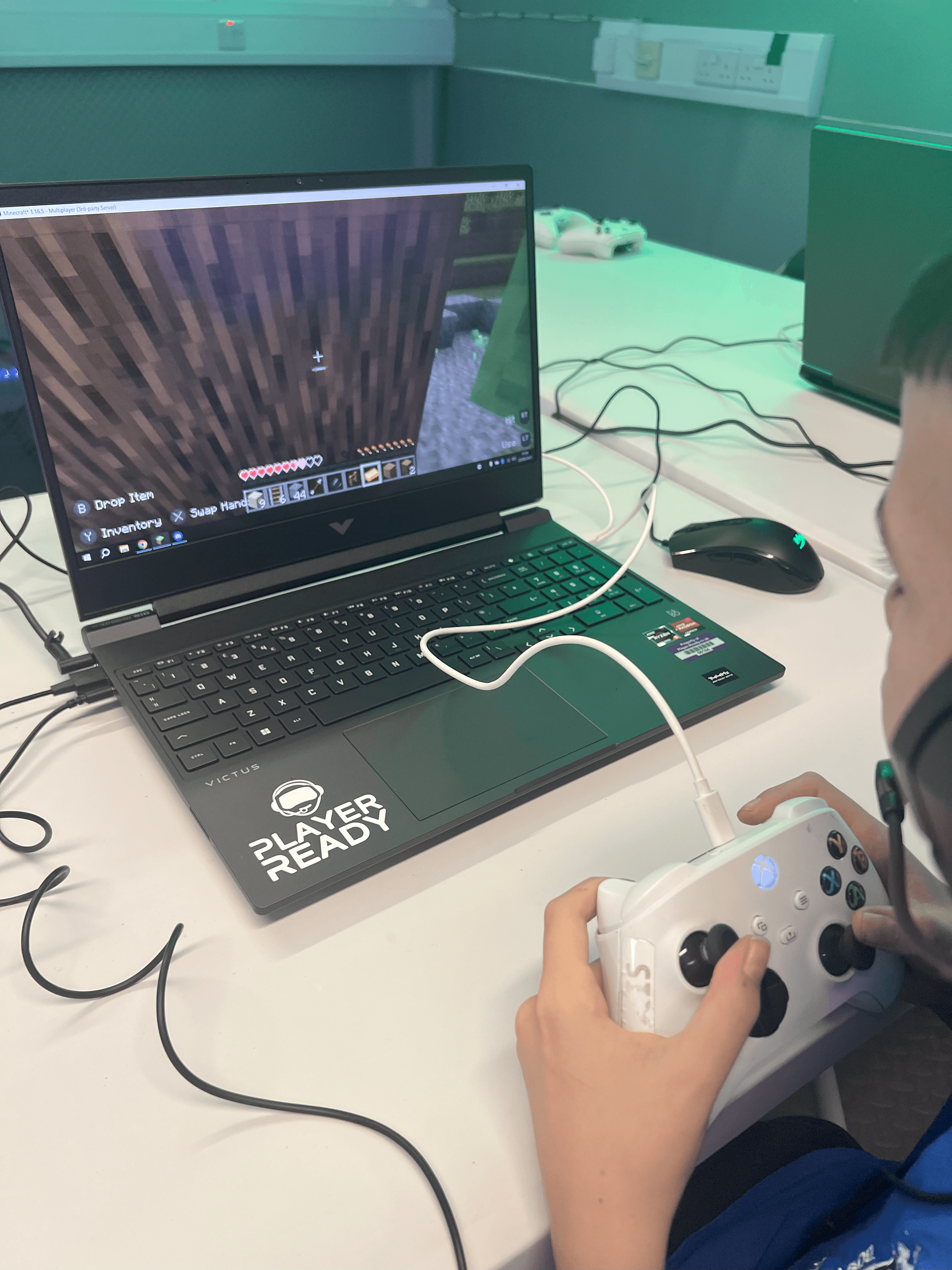 Over-the-shoulder view of a student modding Minecraft on a laptop at Player Ready