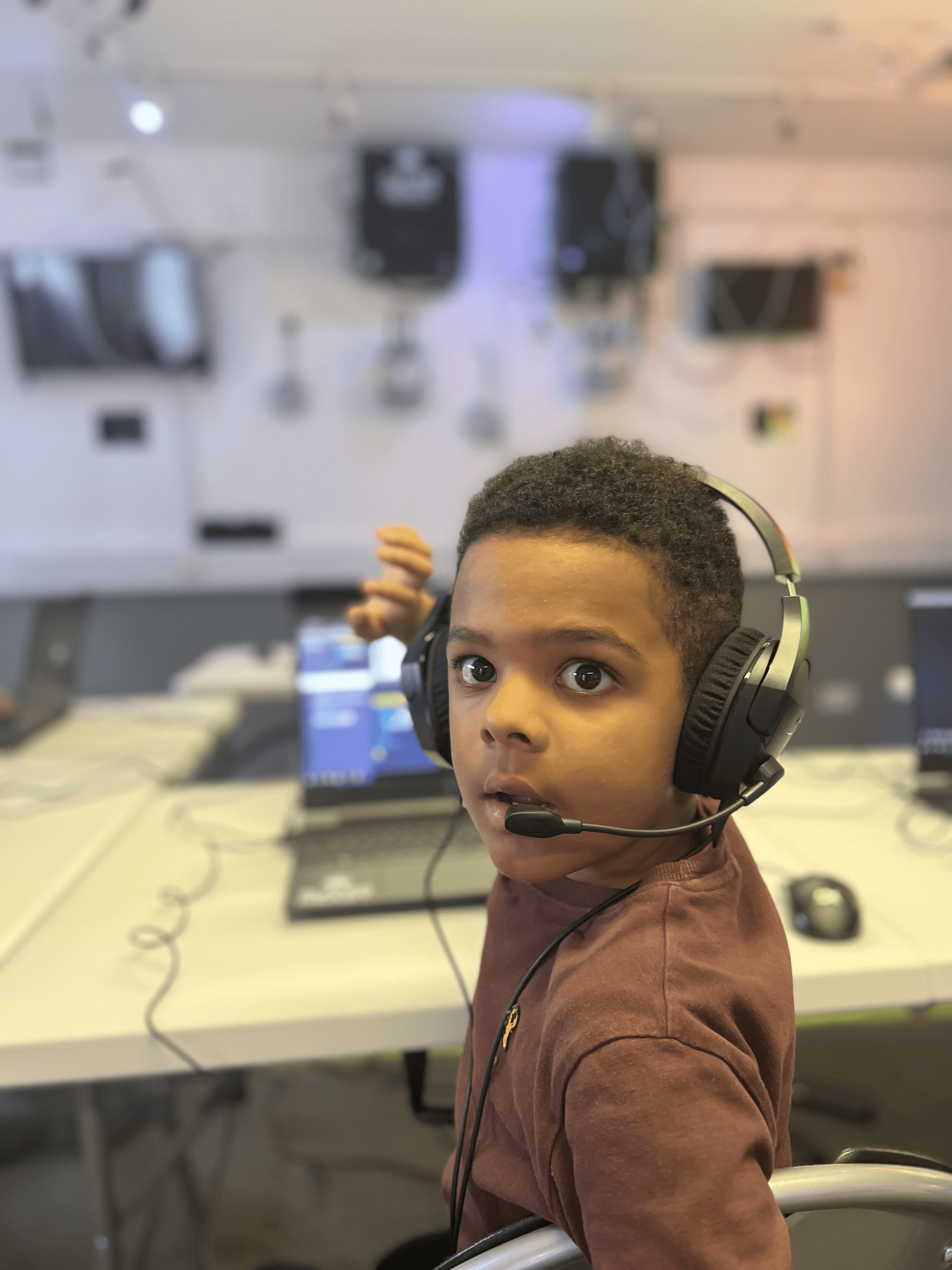 A young student wearing a headset at a Player Ready venue, engaged in a coding session