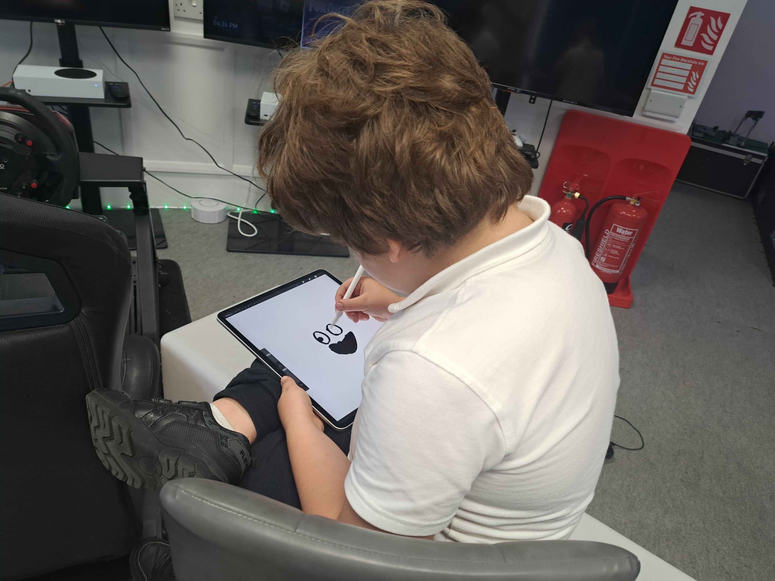 A young person creating digital artwork on an iPad with Apple Pencil at Player Ready